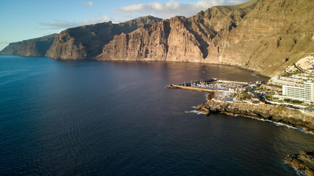 Aerial view of Los Gigantes cliffs and marina in Tenerife, Spain, during the day.
