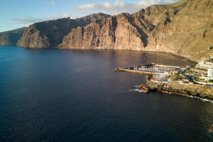 Aerial view of Los Gigantes cliffs and marina in Tenerife, Spain, during the day.